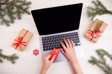 İnternetten alışveriş. Kadınların elleri kredi kartı tutar. Noel hediyesi almak için çevrimiçi bir mağazadan alışveriş yapmak