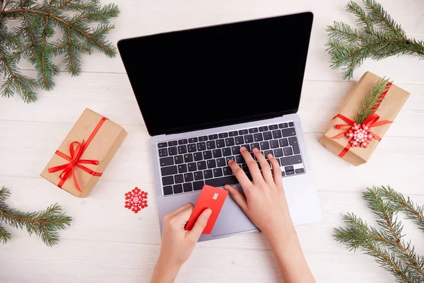 İnternetten alışveriş. Kadınların elleri kredi kartı tutar. Noel hediyesi almak için çevrimiçi bir mağazadan alışveriş yapmak