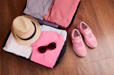  Yaklaşan gezi için içinde kadın kıyafetleri ve aksesuarları olan açık bir bavul. - Evet. Yüksek kalite fotoğraf