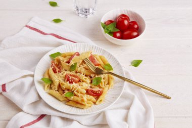 Domatesli makarna, arka planda fesleğen. Geleneksel İtalyan yemekleri. 