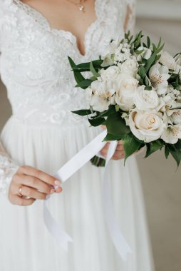 Beyaz elbiseli şık gelin düğün buketini tutuyor.