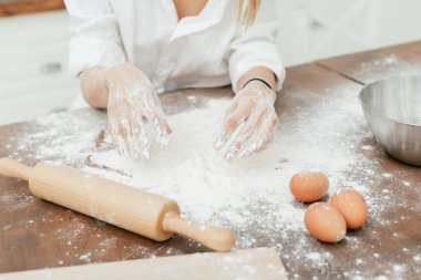 Kız hamuru hazırlıyor. Un ahşap raptiyeye yakın eller.