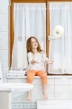 tuvalet kağıdı rulosu ile oynarken sevimli küçük kız