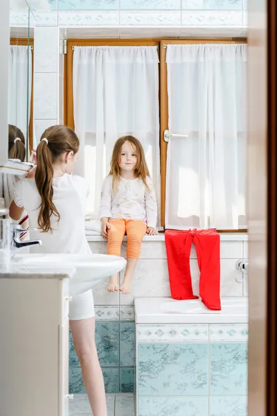 Carino bambina seduta su una finestra del bagno — Foto Stock