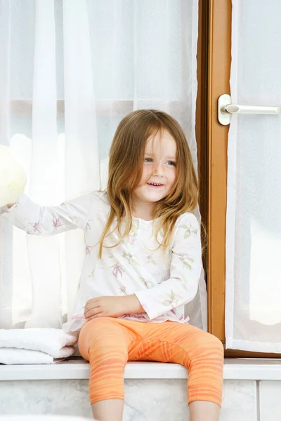 Cute little girl playing with toilet paper roll — Stock Photo, Image