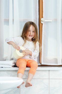 tuvalet kağıdı rulosu ile oynarken sevimli küçük kız