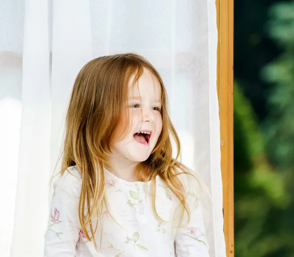 Cute little girl sitting on a bathroom window — Stock Photo, Image