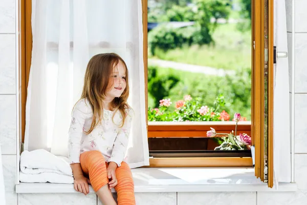 Carino bambina seduta su una finestra del bagno — Foto Stock