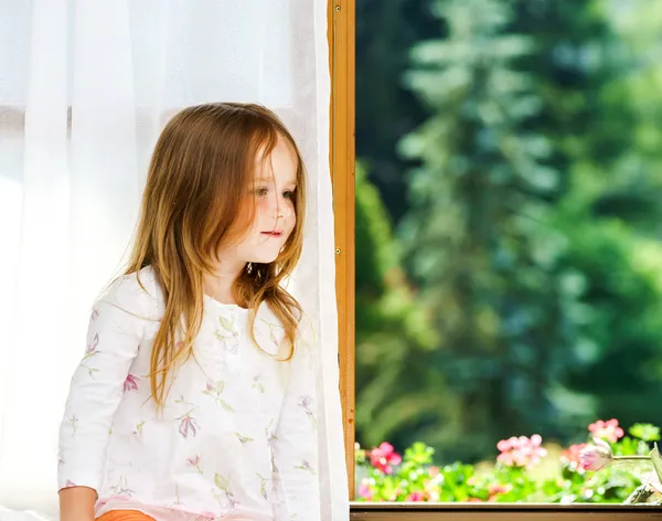 Carino bambina seduta su una finestra del bagno — Foto Stock