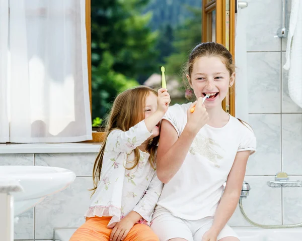 Deux sœurs qui nettoient les dents ensemble — Photo