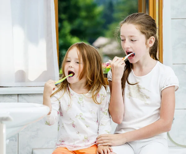 Due sorelle pulire i denti insieme — Foto Stock