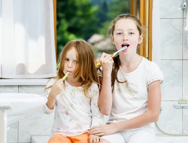 Dos hermanas limpiando los dientes juntas —  Fotos de Stock