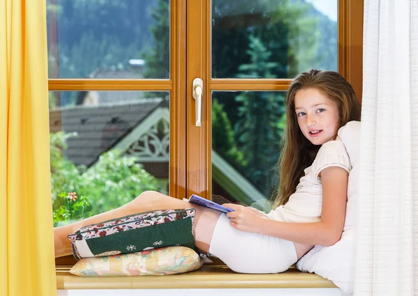 Roztomilé dospívající dívka sedící na okno siil — Stock fotografie