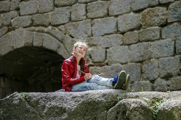 Genç kız oturuyor ve boyama — Stok fotoğraf