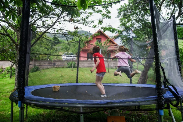 Zwei glückliche Schwestern auf dem Trampolin — Stockfoto