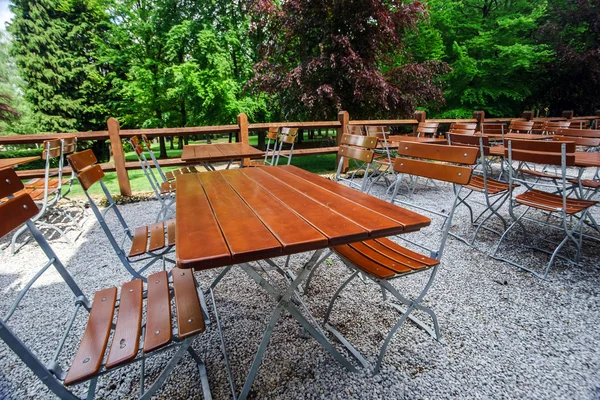Cadeiras e mesas de madeira no café do parque — Fotografia de Stock