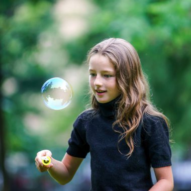 Sabun köpüğü ile oynayan genç kız