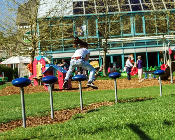 Teenage girl jumping on child playground — Stock Photo, Image