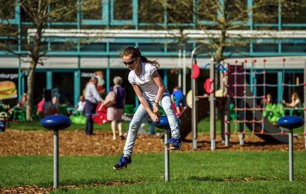 Tienermeisje springen op kind Speeltuin — Stockfoto