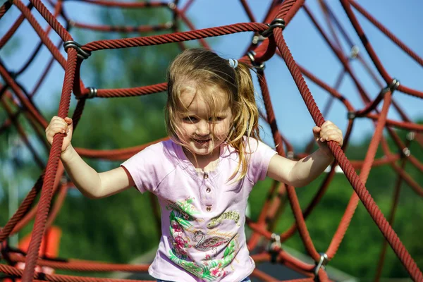 Bonito menina jogando jogo no parque infantil — Fotografia de Stock