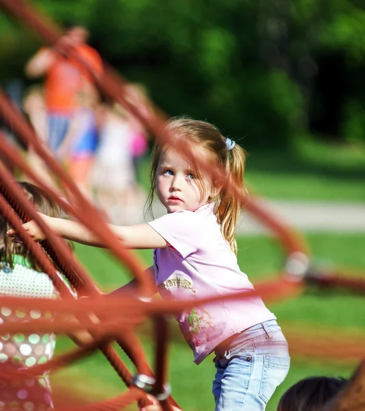 Petite fille mignonne jouant au jeu sur l'aire de jeux pour enfants — Photo