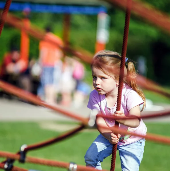 Petite fille mignonne jouant au jeu sur l'aire de jeux pour enfants — Photo