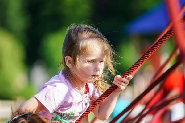 Bonito menina jogando jogo no parque infantil — Fotografia de Stock