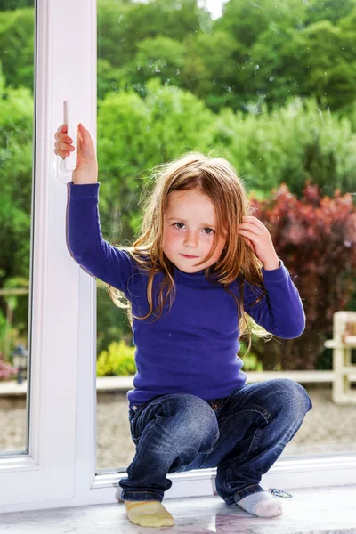 Niedliches kleines Mädchen und PVC-Fenster — Stockfoto