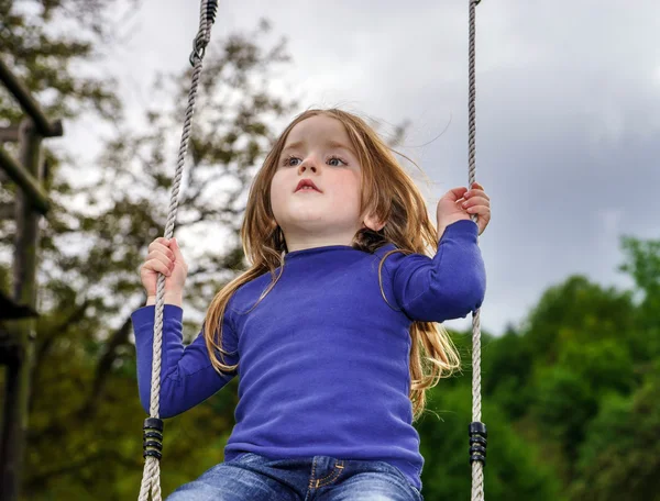 Tahterevalli üzerinde sallanan sevimli küçük kız — Stok fotoğraf