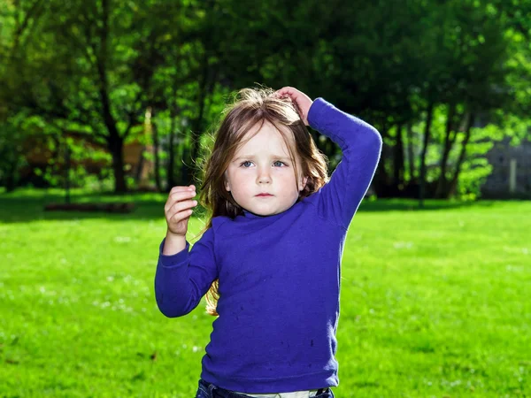Cute little girl on green grass background — Stock Photo, Image