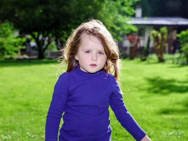Roztomilá holčička na zelené trávě pozadí — Stock fotografie