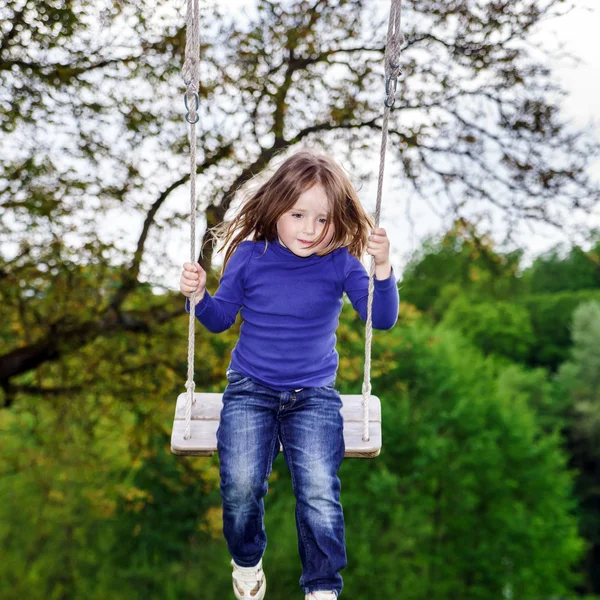 Mignonne petite fille balançant sur balançoire — Photo