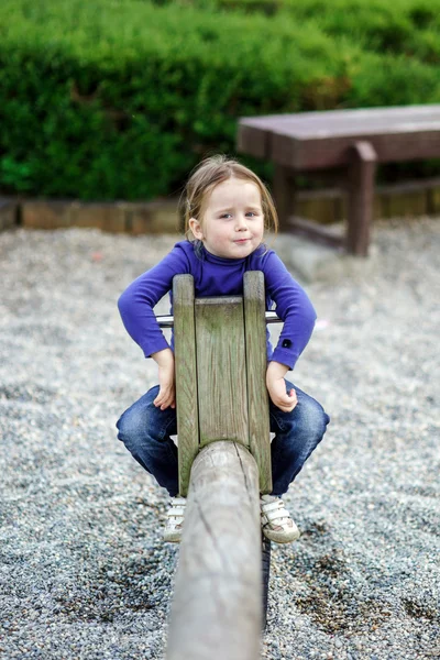 Tahterevalli üzerinde sallanan sevimli küçük kız — Stok fotoğraf