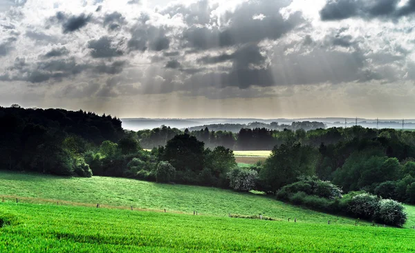 Güneş ışınları yeşil tepelerin üstünde — Stok fotoğraf