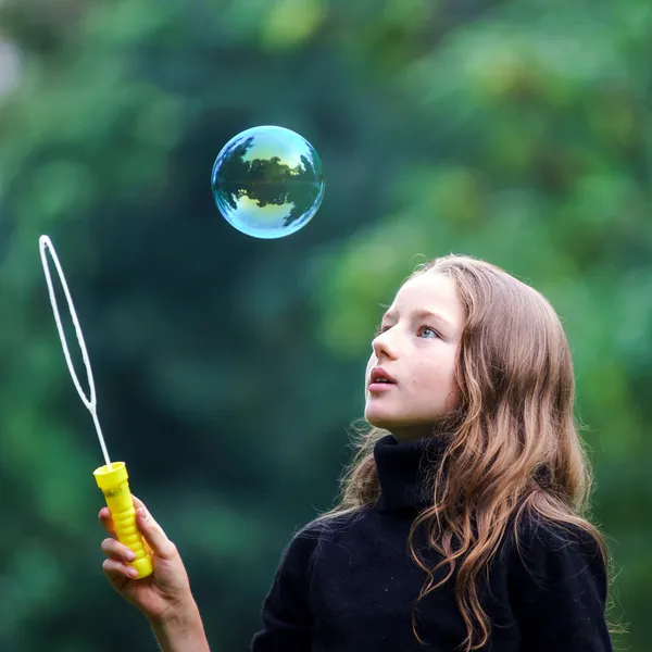 Jong meisje spelen met zeepbellen — Stockfoto