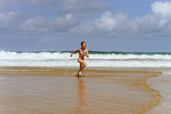 Chica joven jugando en la costa del océano —  Fotos de Stock