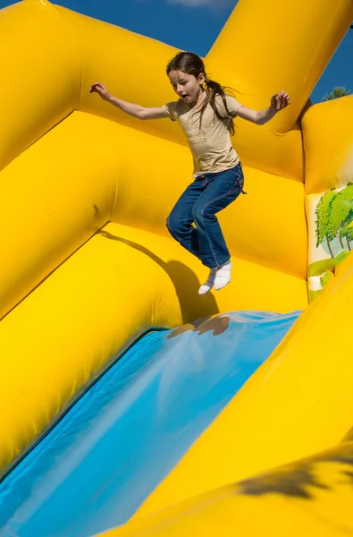 Chica joven saltando en las atracciones — Foto de Stock