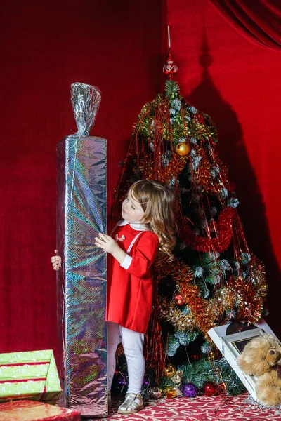 Cute little girl with big sweet christmas gift — Stock Photo, Image