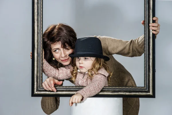Mother and daughter posing with frame — Stock Photo, Image