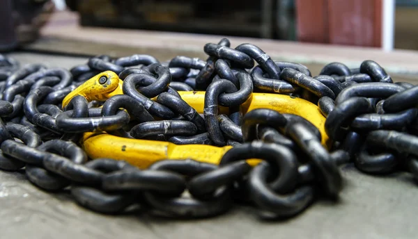 Catena in metallo nero con gancio giallo — Foto Stock