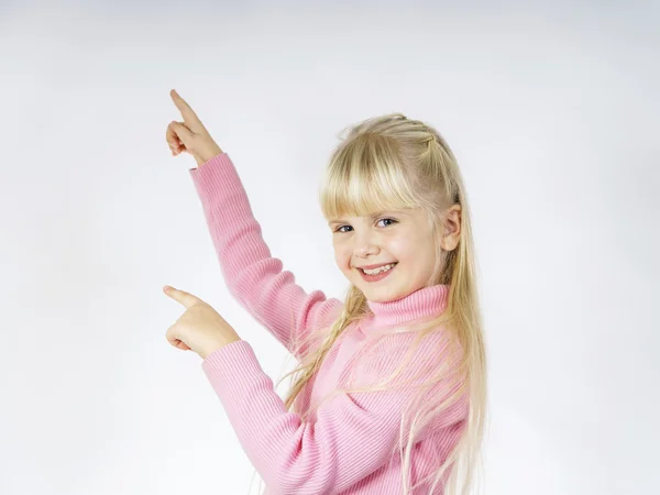 Cute little towhead girl showing to white sheet — Stock Photo, Image
