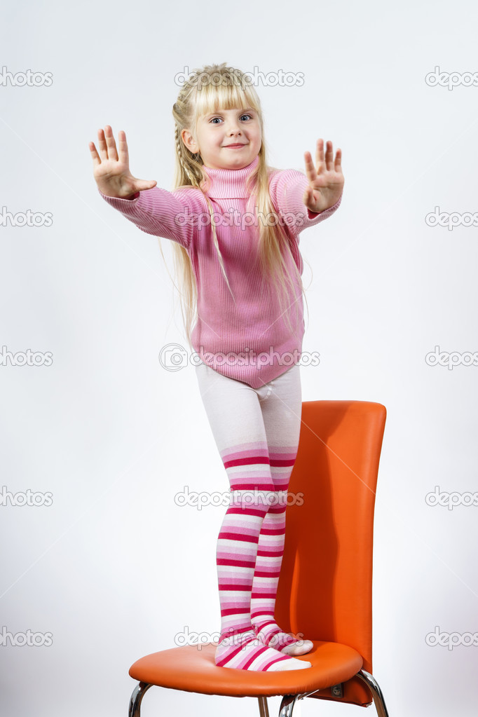 Cute little towhead girl standing on chair
