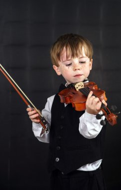 çilli kızıl saçlı çocuk keman çalıyor.