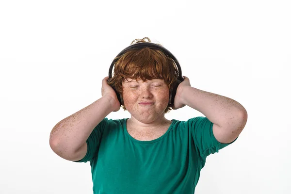 Freckled red-hair boy listening music. — Stock Photo, Image