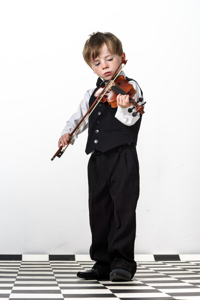 Freckled red-hair boy playing violin.