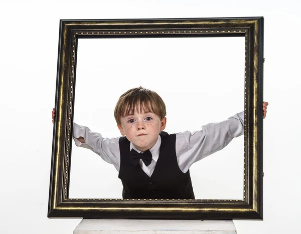 Freckled red-hair little boy with big picture frame. — Stock Photo, Image