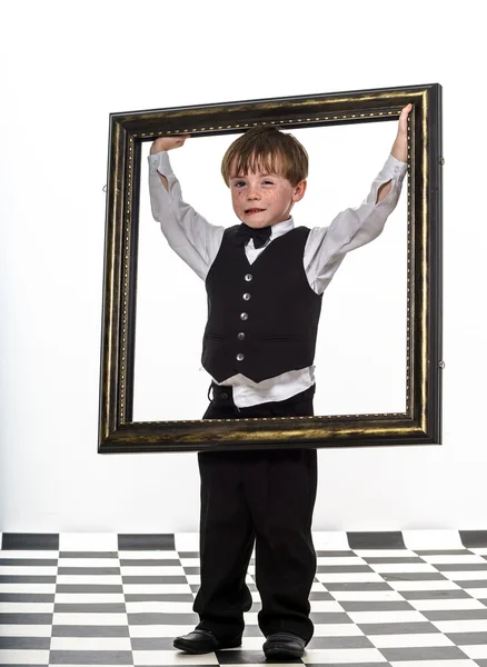 Freckled red-hair little boy with big picture frame. — Stock Photo, Image