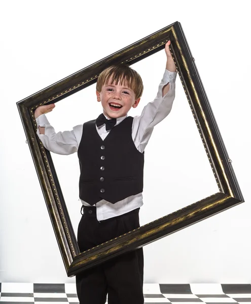 Freckled red-hair little boy with big picture frame. — Stock Photo, Image