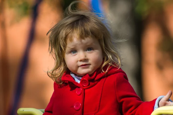 Överraskande liten flicka klä i röd kappa — Stockfoto