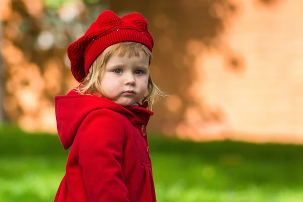 Cute little girl dressing in red coat — Stock Photo, Image